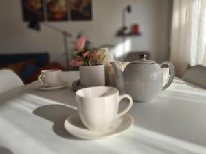 a table with two cups and a tea pot on it at TARNO Lake Apartment in Tarnobrzeg