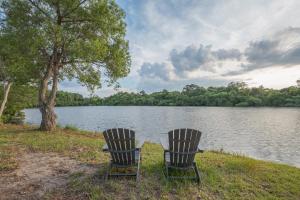 two chairs sitting on the shore of a lake at 1064 - Sunset Cottage in Corolla