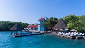 a resort on a dock in the water with lounge chairs at Fragata Island House in Isla Grande