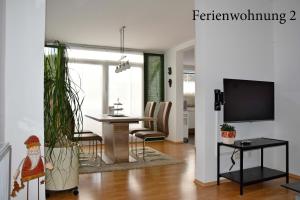 a living room with a television and a dining room at Ferienwohnung Janssen Herborn in Herborn