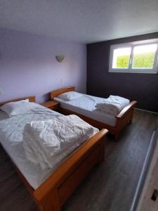 zwei Einzelbetten in einem Schlafzimmer mit Fenster in der Unterkunft Ty Kerlen in Quimperlé