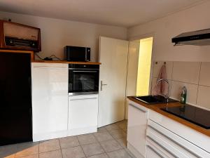 a kitchen with white cabinets and a black refrigerator at Monteurwohnung Inzlingen nahe Basel in Inzlingen +5 photos