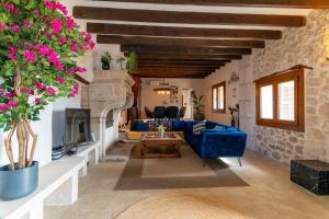 a living room with a blue couch and a fireplace at Villa My Love Mallorca in Bunyola