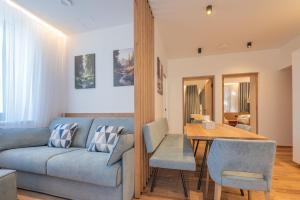 a living room with a blue couch and a table at Appartament Lago di Braies in San Sigismondo