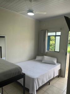 a bedroom with a white bed with a window at Pousada do Rei in Sarzedo