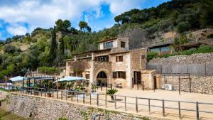 a house on a hill with tables and umbrellas at Villa My Love Mallorca in Bunyola