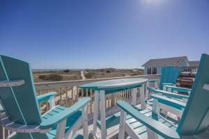 a row of chairs and tables on a deck with the beach at 7158 - A Wave From It All in Waves