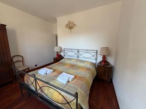 a bedroom with a bed with two towels on it at Arma central Garden in Arma di Taggia