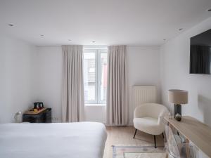 a bedroom with a bed and a chair and a window at Suzan's Guesthouse in Ghent
