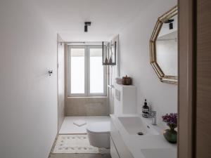 a bathroom with a toilet and a sink and a mirror at Suzan's Guesthouse in Ghent