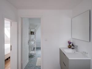 a white bathroom with a sink and a mirror at Suzan's Guesthouse in Ghent