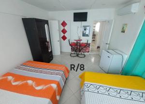 a room with two beds and a table in it at Wilkan Hotel in Las Terrenas