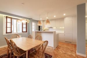 a kitchen and dining room with a wooden table and chairs at VIVA Serpa Pinto Serviced Apartments in Porto