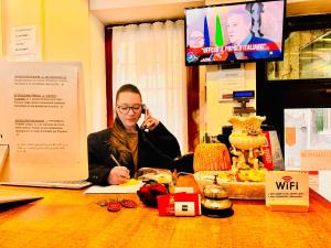 a woman sitting at a table talking on a cell phone at Hotel Henry Venice in Venice