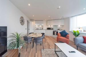 a kitchen and living room with a table and chairs at Bright 2BR Apartment at Trinity Point in Gravesend