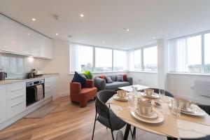 a kitchen and living room with a table and chairs at Bright 2BR Apartment at Trinity Point in Gravesend