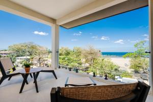 a balcony with a view of the beach at Iguana Surf Boutique Hotel Tamarindo Rooftop Pool & Beachfront Suites in Tamarindo +76 photos
