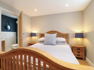 a bedroom with a wooden bed and a bathroom at Farm View House in Melton Mowbray