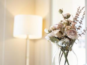 a glass vase filled with flowers in a room at Noble Floor - Panoramic Luxury Apartment in Lucca