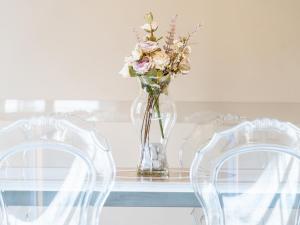 a vase of flowers sitting on a table with two chairs at Noble Floor - Panoramic Luxury Apartment in Lucca +27 photos