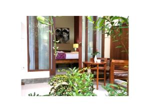 a room with a bed and a table with plants at Narendra Guest House in Ubud