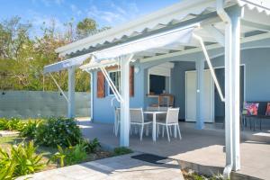 a blue house with a white pergola at Villa Sibaloma in Saint-François