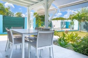a white dining table and chairs on a patio at Villa Sibaloma in Saint-François