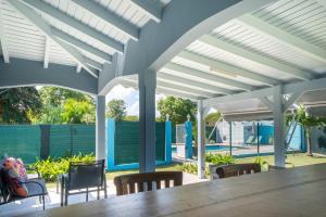 a patio with a table and chairs and a pool at Villa Sibaloma in Saint-François