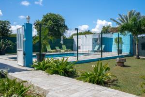 a tennis court with a fence around a pool at Villa Sibaloma in Saint-François