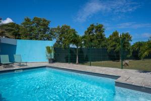 a swimming pool in front of a fence at Villa Sibaloma in Saint-François +21 photos