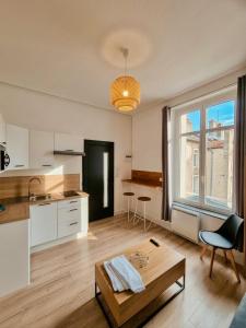 a living room with a table and a kitchen at Appartement à thermal in Nancy
