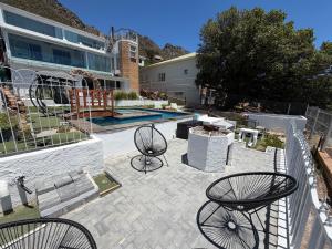 a patio with two tables and two chairs at Kiwara at C, Gordon's Bay in Gordonʼs Bay