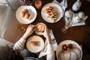 a person sitting at a table with plates of food at Ansitz Thierburg Suites in Merano