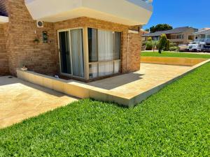 a house with a patio and green grass at Ocean Breeze in Perth