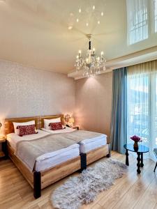 ein Schlafzimmer mit einem großen Bett und einem Kronleuchter in der Unterkunft Hotel Gold Tower in Mestia
