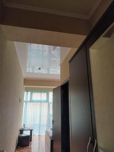 a living room with a large window and a sliding door at Saburtalo Central in Tbilisi City