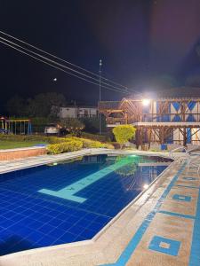 a large swimming pool at night at La orquídea campestre in Montenegro +8 photos