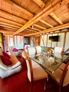 a living room with a glass table and chairs at La orquídea campestre in Montenegro