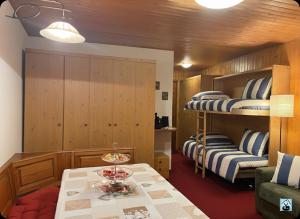 a room with two bunk beds and a table at Soldanella Cervinia apartment Vda Vacanze in Vetta CIR 0253 in Breuil-Cervinia