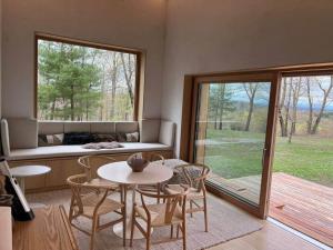 a living room with a table and chairs and a window at Architectural Cabin 18 mins to Catamount in Taghkanic +6 photos