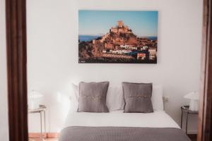 a bedroom with a bed with a mountain painting on the wall at Las Chavitas Rural Apartamentos turísticos in Alburquerque