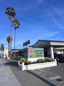 a building with a sign for a hotel with palm trees at Bermuda Palms Hotel in San Rafael