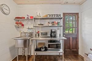 a kitchen with a sink and a microwave at Suite Elliana w/Hot Tub & Outdoor Fireplace! in Fredericksburg