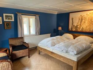 a bedroom with a large bed in a blue room at Ferienhaus Nicklas in Bad Schandau
