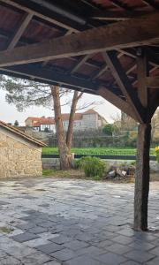 a stone patio with a tree in the background at Casa do Fundão in Paredes