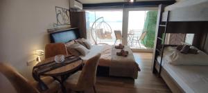a bedroom with a bed and a table and a balcony at Pearl's apartments Old town Ohrid in Ohrid