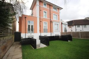 a large house with a green lawn in front of it at Osterley Place - Apt A in Hounslow