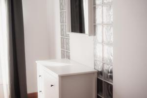 a kitchen with white cabinets and a wall with glass tiles at Las Chavitas Rural Apartamentos turísticos in Alburquerque +92 photos