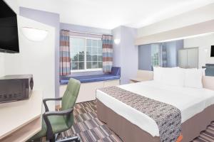 a hotel room with a bed and a tv at Microtel Inn and Suites by Wyndham Appleton in Appleton
