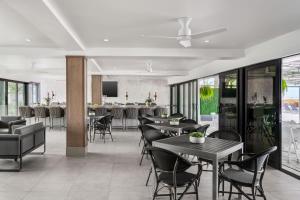 a restaurant with tables and chairs and a bar at Bilmar Beach Resort in St. Pete Beach